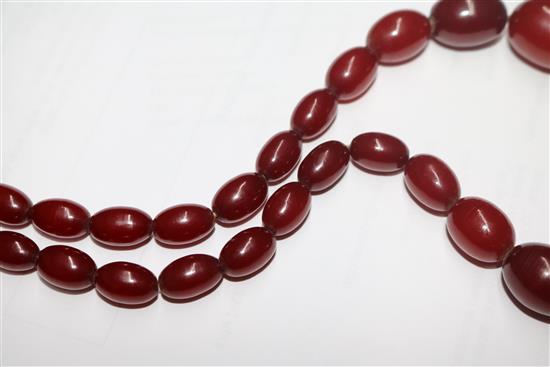 A single strand graduated simulated cherry amber oval bead necklace, gross weight 68 grams, 70cm.